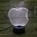 3D fruit-shaped colourful LED night light with touch control on a table.