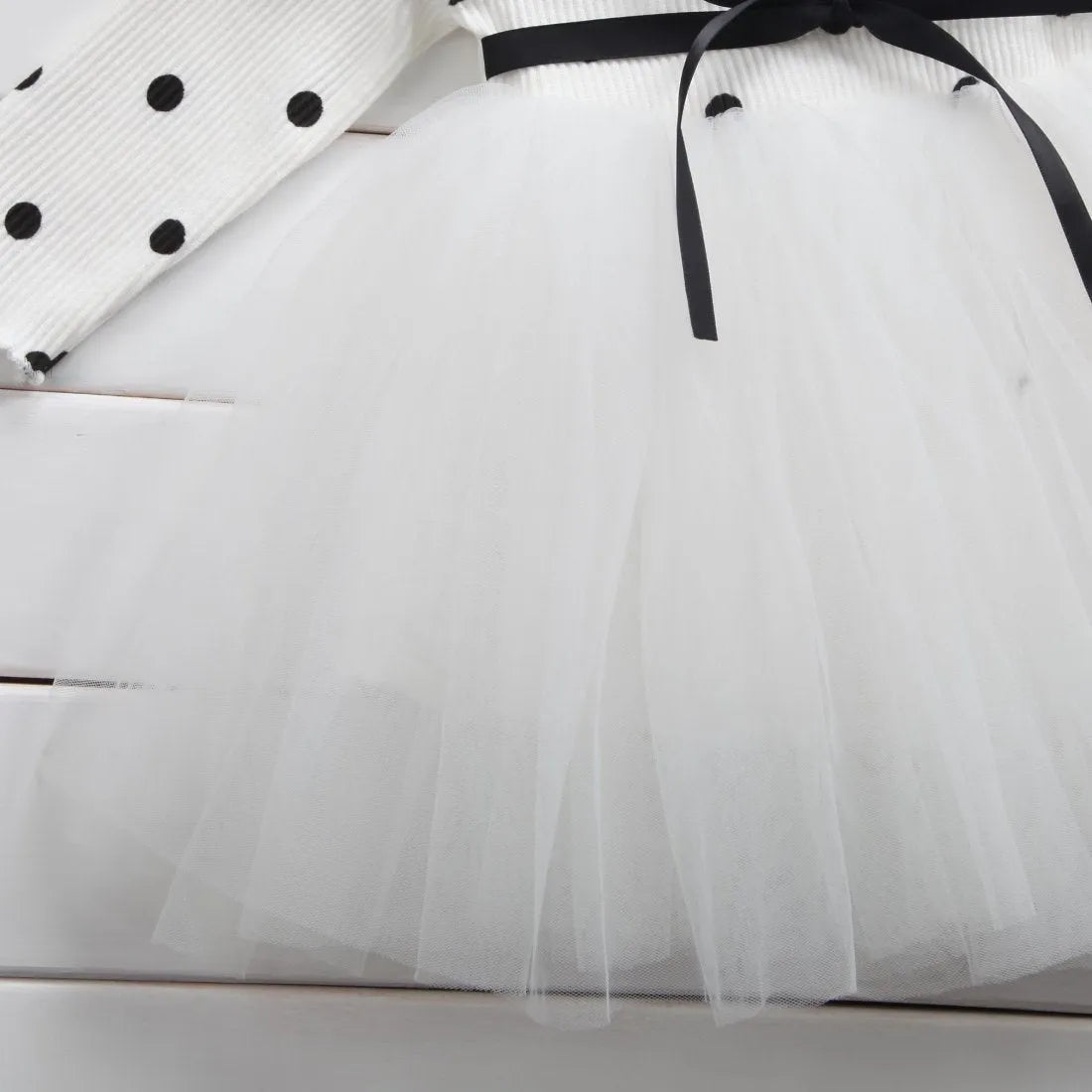 A baby girl's long sleeve black tutu dress with lace detail, suitable for birthdays and christenings.