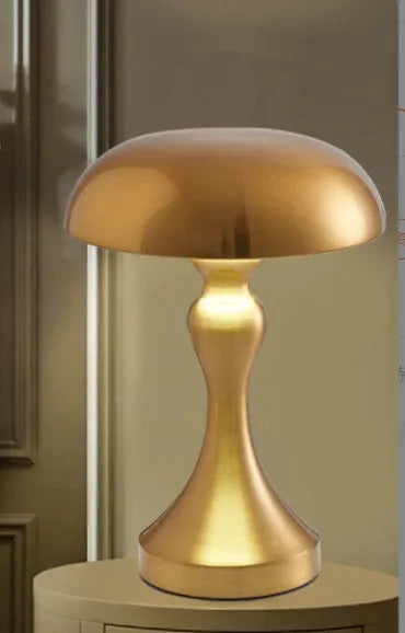 Metallic finish desk lamp with touch control and USB charging cable on a wooden desk