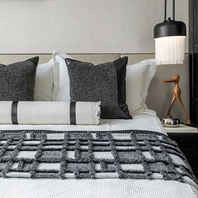 Modern minimalist grey and white plaid bed runner set with pillowcase and round leather pillow on bed