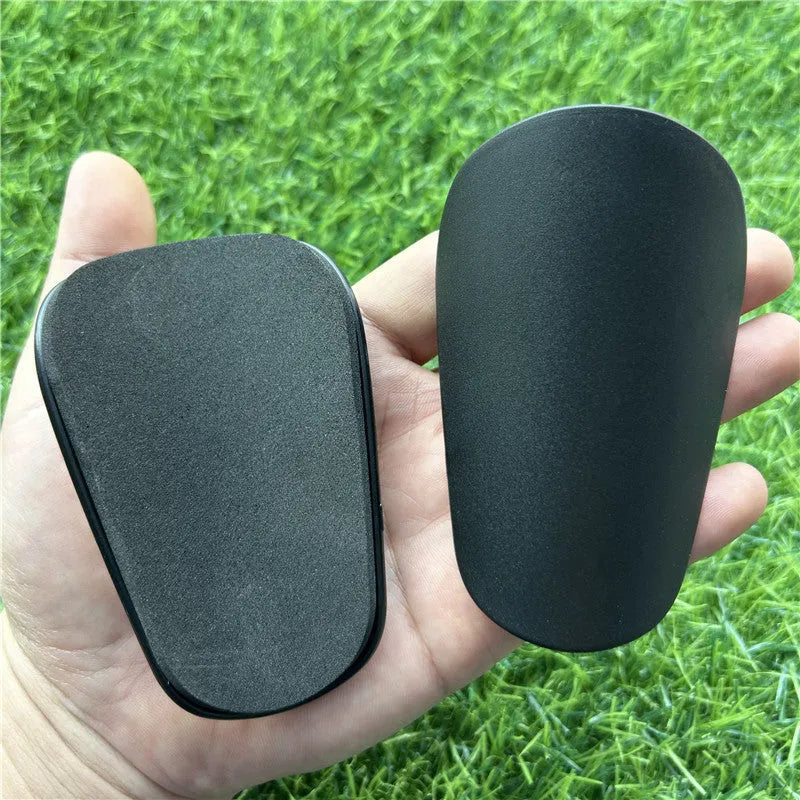 Extra small mini football shin guards measuring 8x5cm in black and white plastic construction