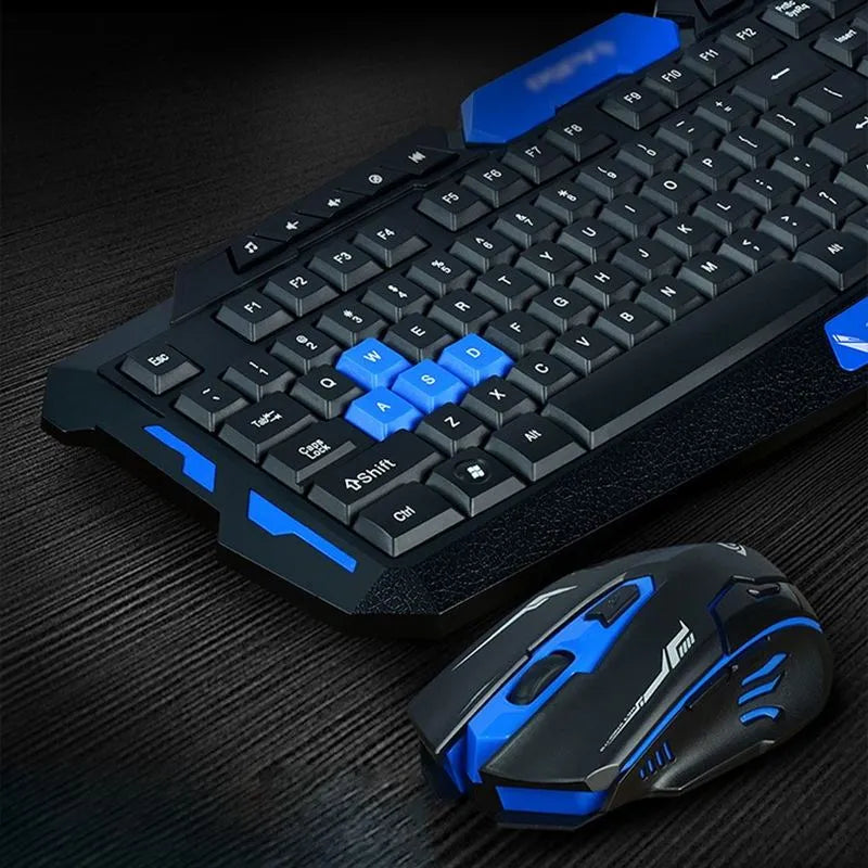 Black and blue wireless keyboard and mouse set on a desk, showing ergonomic design and multimedia keys.