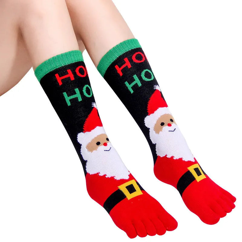 Christmas five finger socks with cartoon patterns in black, green, and white on a neutral background