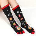 Christmas five finger socks with cartoon patterns in black, green, and white on a neutral background