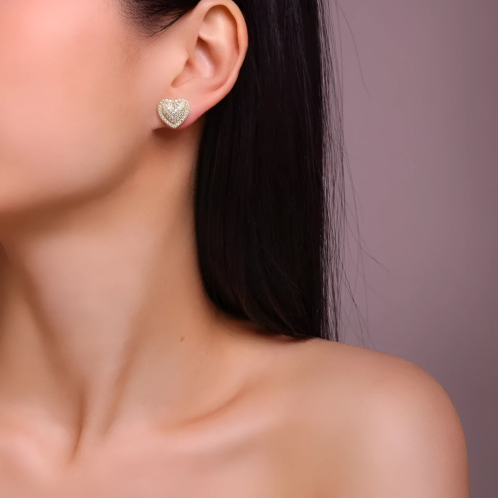 A pair of gold-toned heart-shaped stud earrings with a moissanite stone, made from S925 silver.