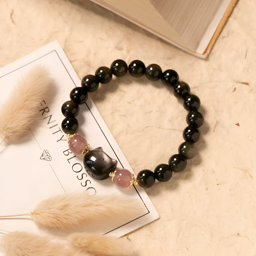 Single circle natural obsidian bracelet with 8mm black beads and kitty cat pendant on white background
