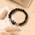 Single circle natural obsidian bracelet with 8mm black beads and kitty cat pendant on white background