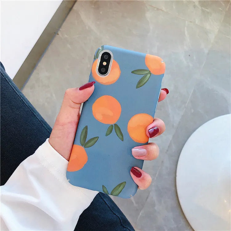 Orange retro plastic iPhone case with water and blue background design on a table.