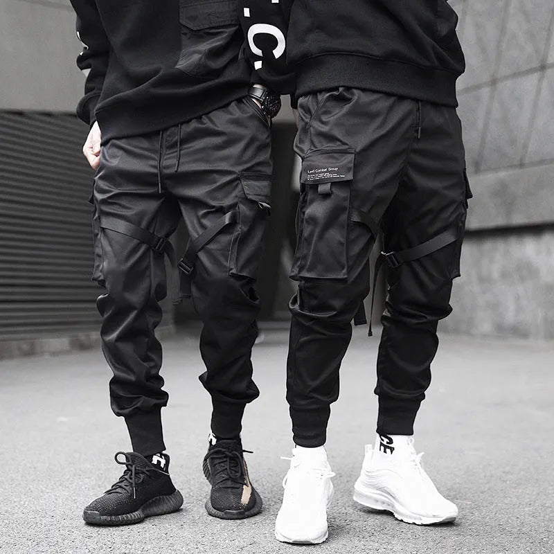 Black cotton overalls with tapered leg and small foot opening on plain background