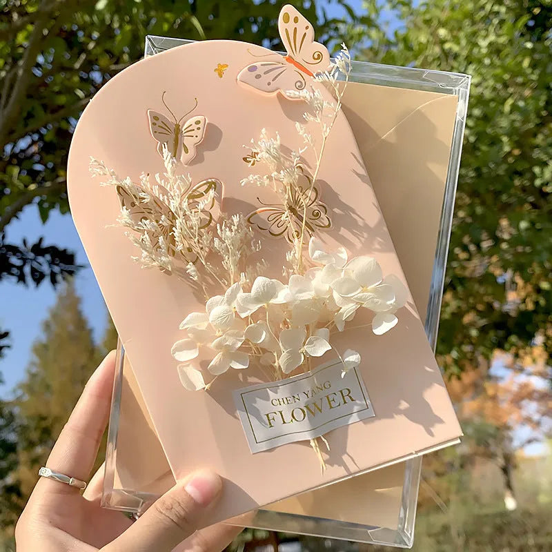 Handmade 3D boxed greeting card with butterfly shape, hot stamping, and artificial flowers on coated paper.