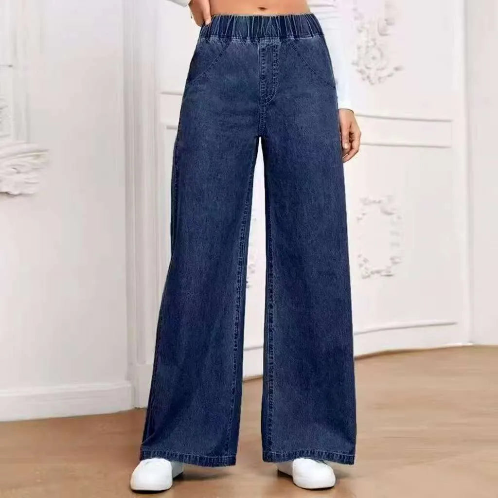 Light blue washed wide-leg denim jeans on a plus-size model, showing straight leg and mid-rise waist.