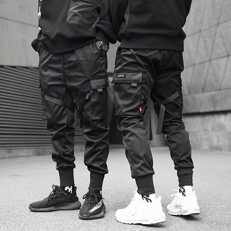 Black cotton overalls with tapered leg and small foot opening on plain background