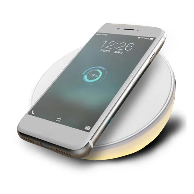 White wireless charger with digital clock display showing time and charging smartphone