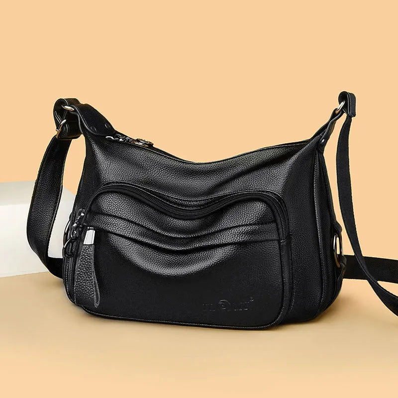 Large blue PU leather crossbody bag for women showing horizontal square shape and internal organiser pockets.