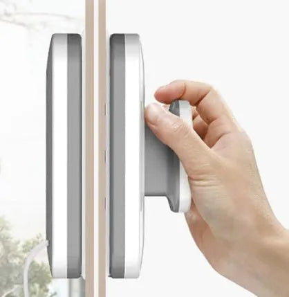 Magnetic double-sided window cleaner with silicone scraper on glass surface, 10x15x4cm size, white ABS body