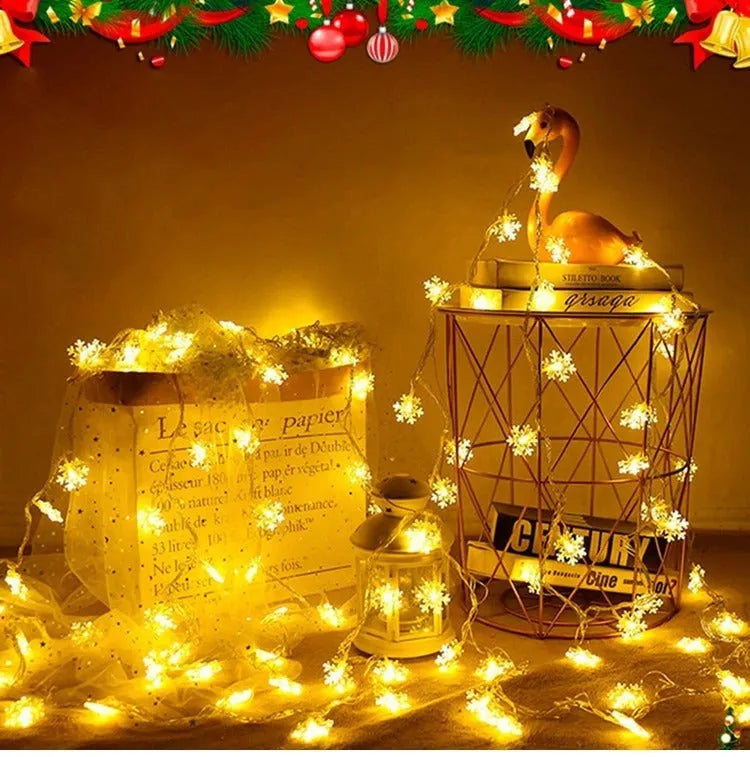 Battery powered LED snowflake string lights with star decorations lit on a dark background
