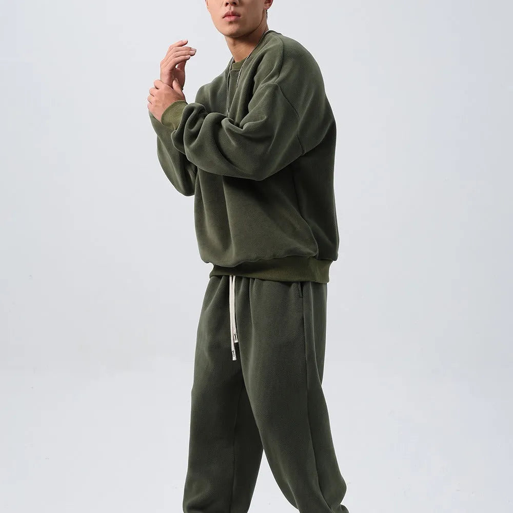 Men's black polar fleece sports suit with loose long sleeve coat and matching trousers on a hanger.