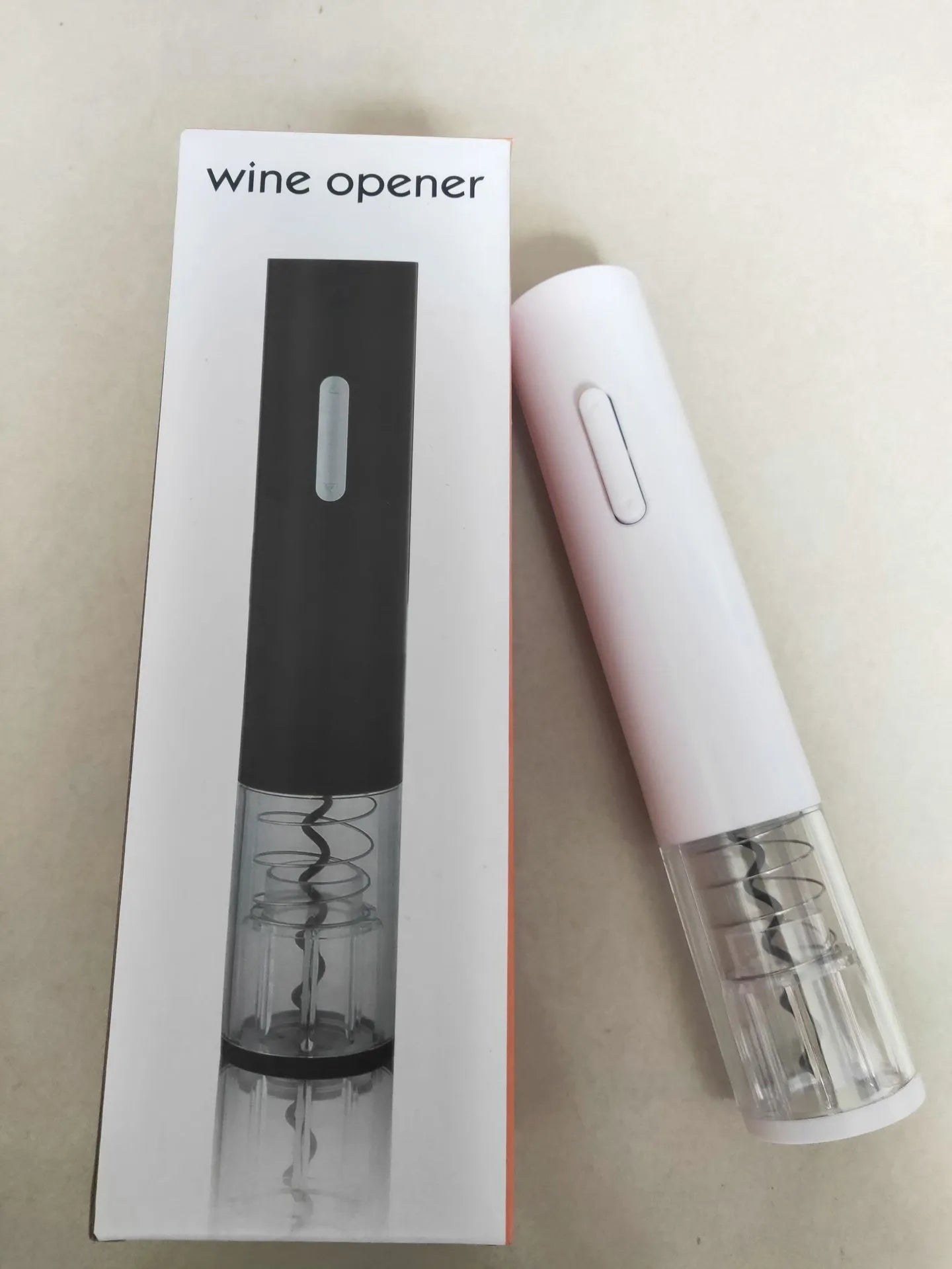 Black automatic electric wine bottle opener with integrated foil cutter on a kitchen counter.