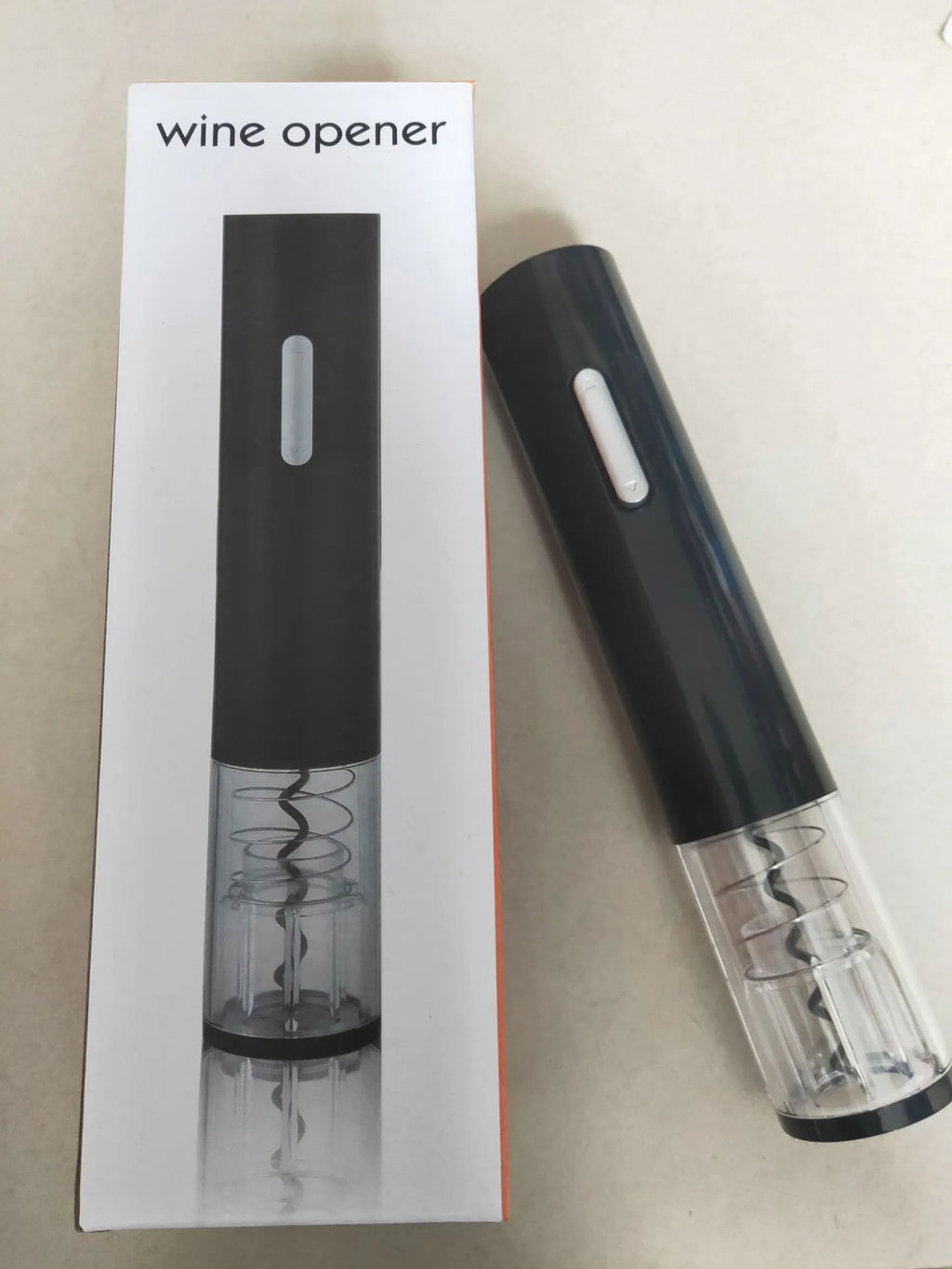 Black automatic electric wine bottle opener with integrated foil cutter on a kitchen counter.