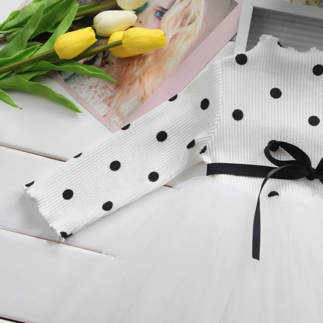 A baby girl's long sleeve black tutu dress with lace detail, suitable for birthdays and christenings.