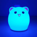 Cartoon silicone clapping lamp in Princess Bear style showing warm white light on a wooden table