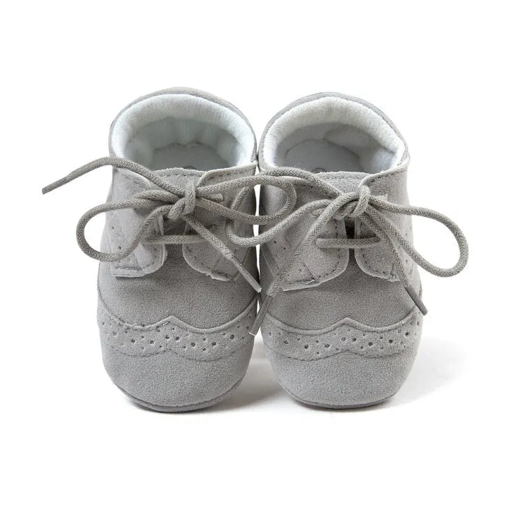 Vintage style soft-soled baby walking shoes for boys in black, grey, light brown, and white.
