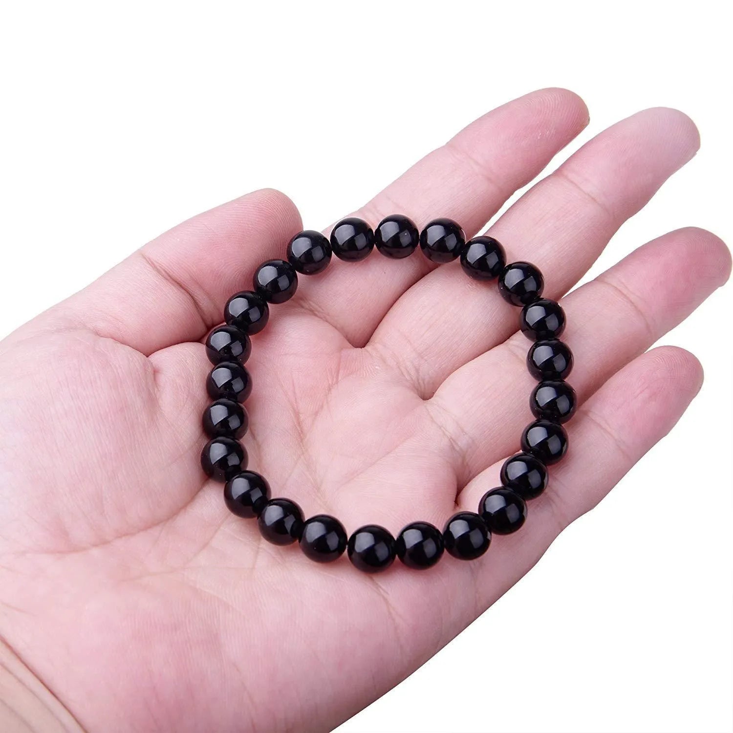 Black onyx geometric bead bracelet with elastic cord on a wrist.
