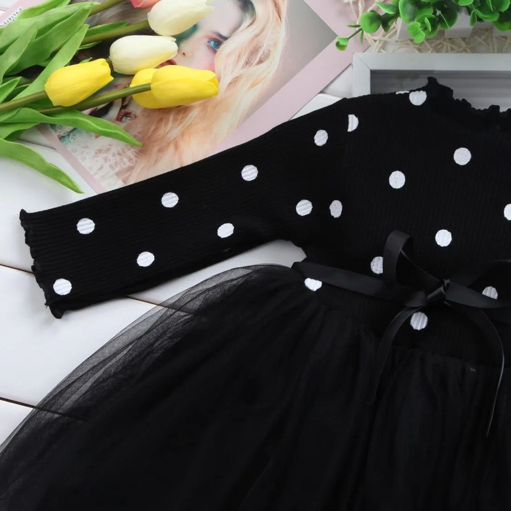 A baby girl's long sleeve black tutu dress with lace detail, suitable for birthdays and christenings.