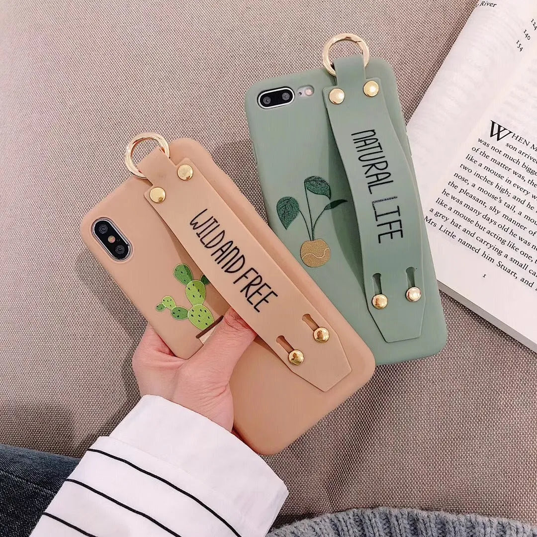 Green graffiti design iPhone case with a black detachable wrist strap looped around a hand.