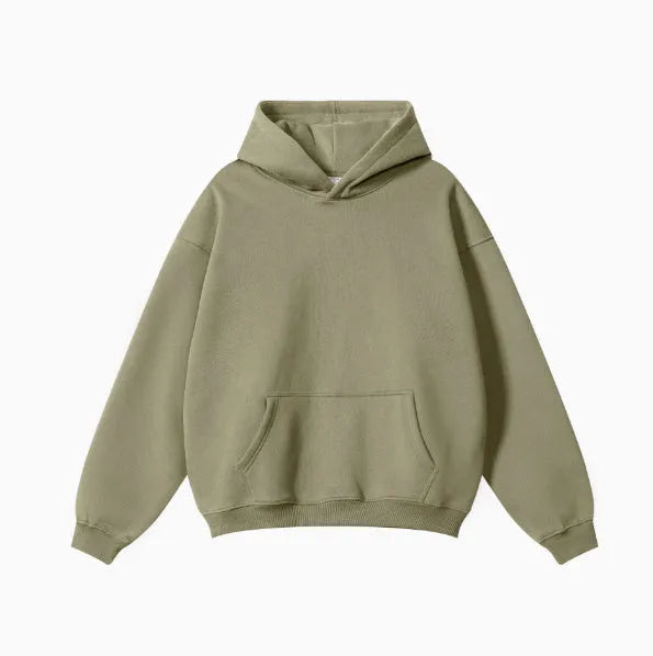 A man wearing a loose-fit, grey, cotton hooded pullover sweater with drop-shoulder sleeves.
