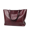 Horizontal leather crossbody handbag in waxed cowhide with two main compartments and a phone pouch.