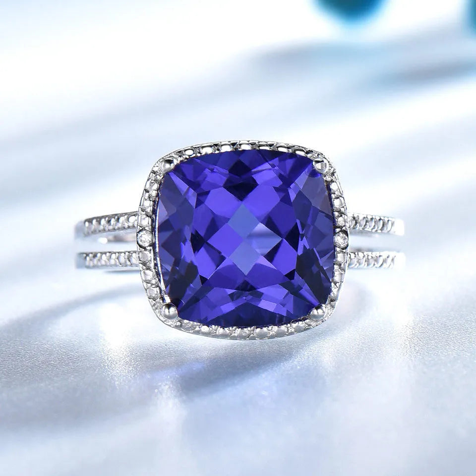 Women's 925 Sterling Silver ring with a blue Tanzanite stone, shown on a finger.