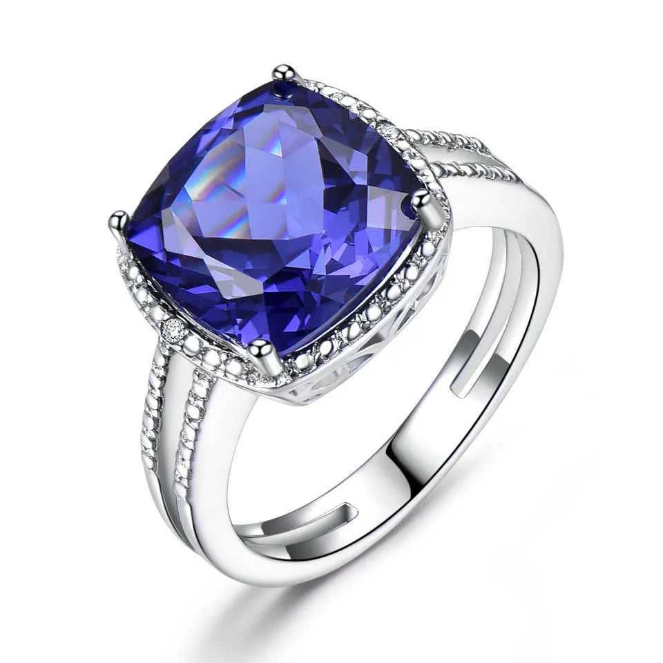Women's 925 Sterling Silver ring with a blue Tanzanite stone, shown on a finger.