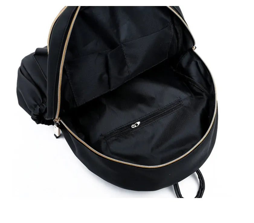 Black waterproof Oxford backpack for women, 34cm high, showing front view on plain background