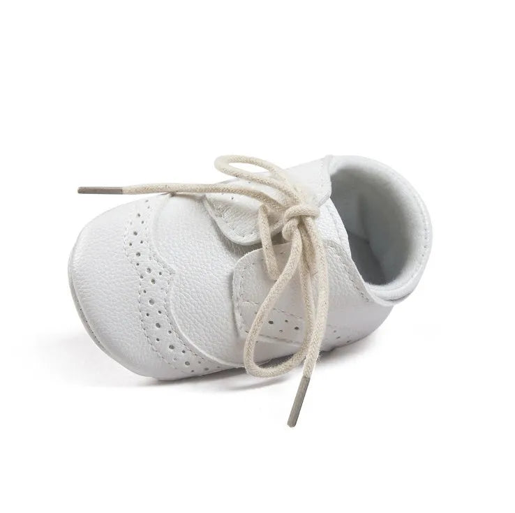 Vintage style soft-soled baby walking shoes for boys in black, grey, light brown, and white.