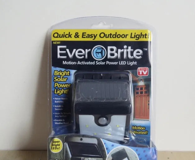 Outdoor solar powered light with 4 LEDs and motion sensor mounted on a garden wall