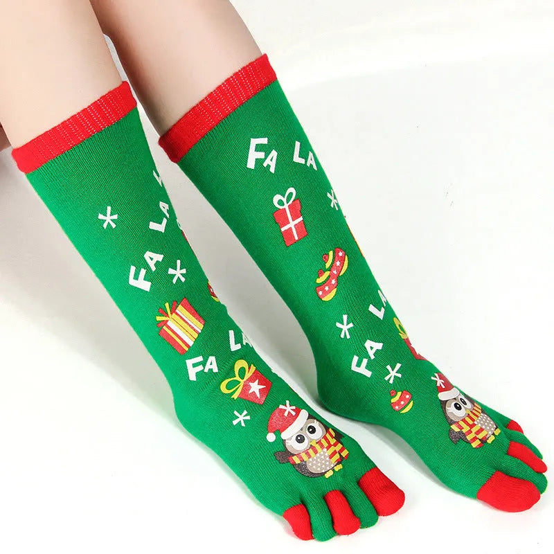 Christmas five finger socks with cartoon patterns in black, green, and white on a neutral background