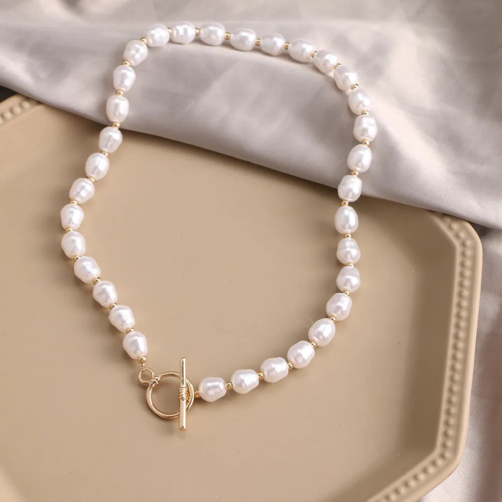 Vintage gold necklace with heart pendant on adjustable pearl chain, showing electroplated finish and love motifs