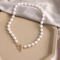 Vintage gold necklace with heart pendant on adjustable pearl chain, showing electroplated finish and love motifs