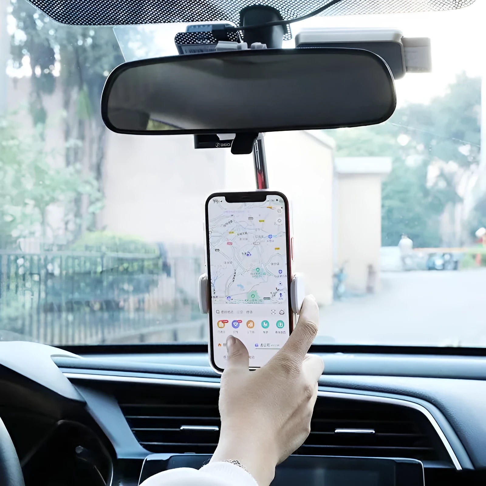 Black mobile phone bracket mounted on car rearview mirror holding smartphone