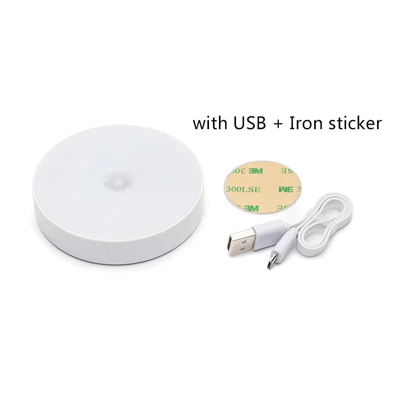 Small round white LED motion sensor night light with USB charging cable and adhesive tape