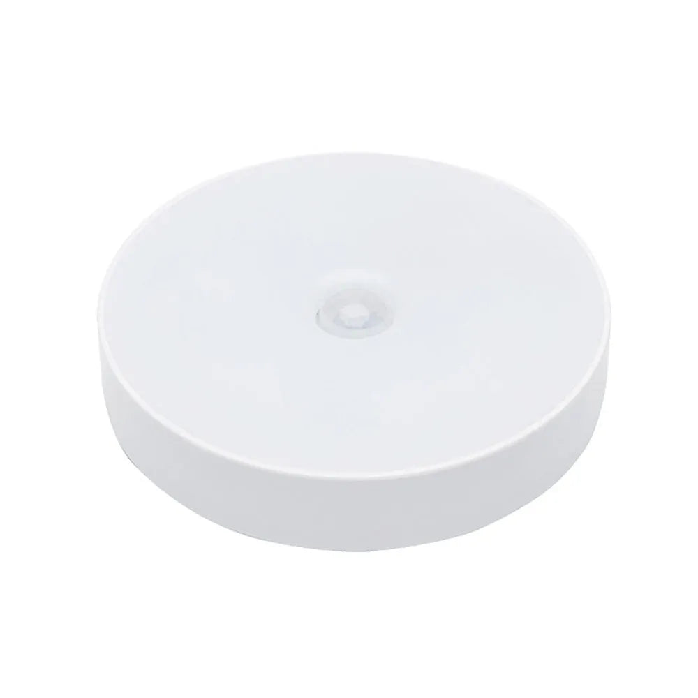 Small round white LED motion sensor night light with USB charging cable and adhesive tape