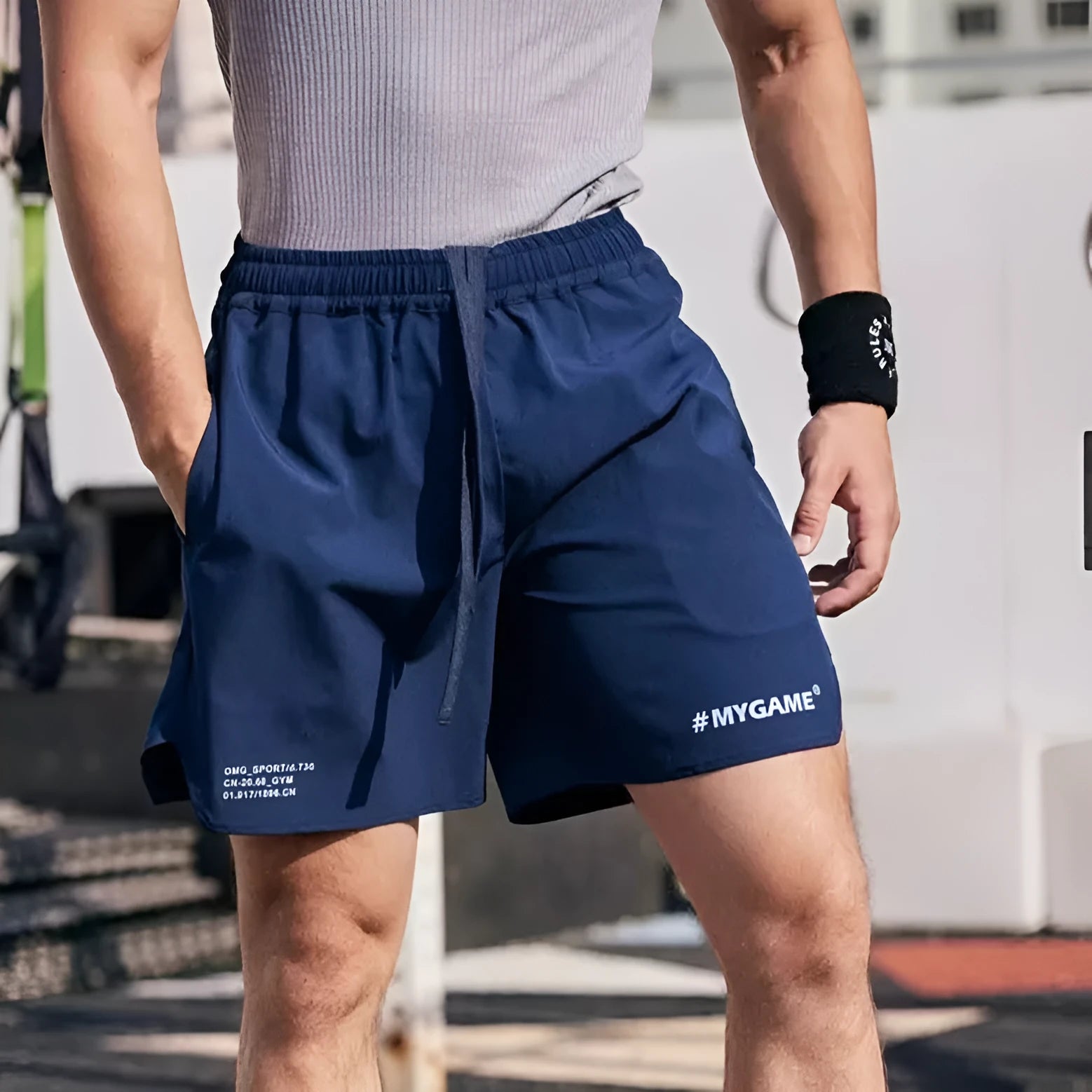 Men's grey fitness training shorts made of quick-dry polyester fabric on a plain background.