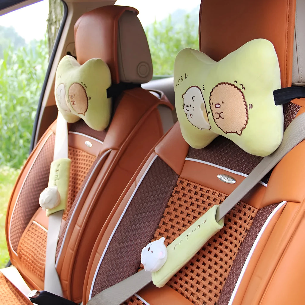 Plush car headrest neck pillow in green and beige with matching safety belt covers and cartoon pattern