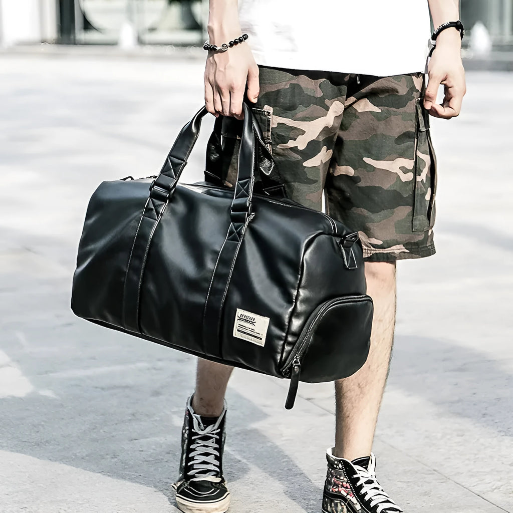 Large black PU leather sports training bag with zipper opening and single strap, showing internal organiser pockets.