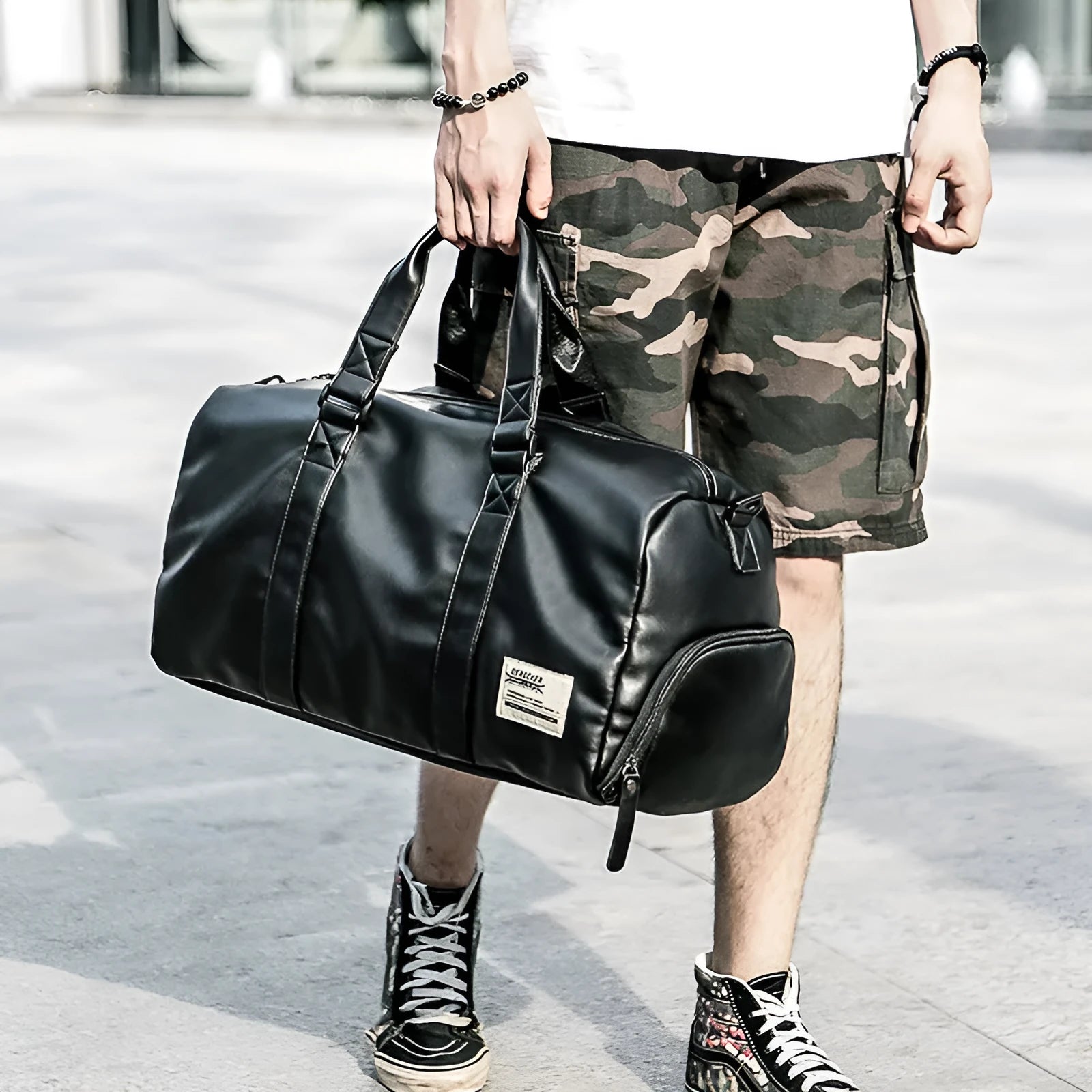 Large black PU leather sports training bag with zipper opening and single strap, showing internal organiser pockets.