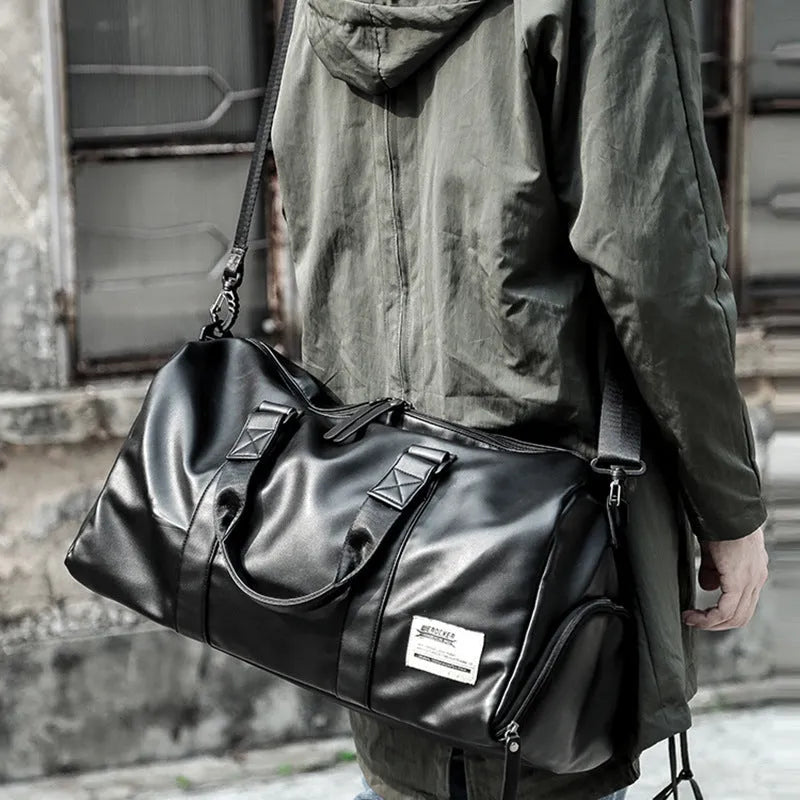 Large black PU leather sports training bag with zipper opening and single strap, showing internal organiser pockets.
