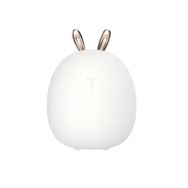 Cartoon deer silicone night light with USB charging cable and touch switch on a bedside table