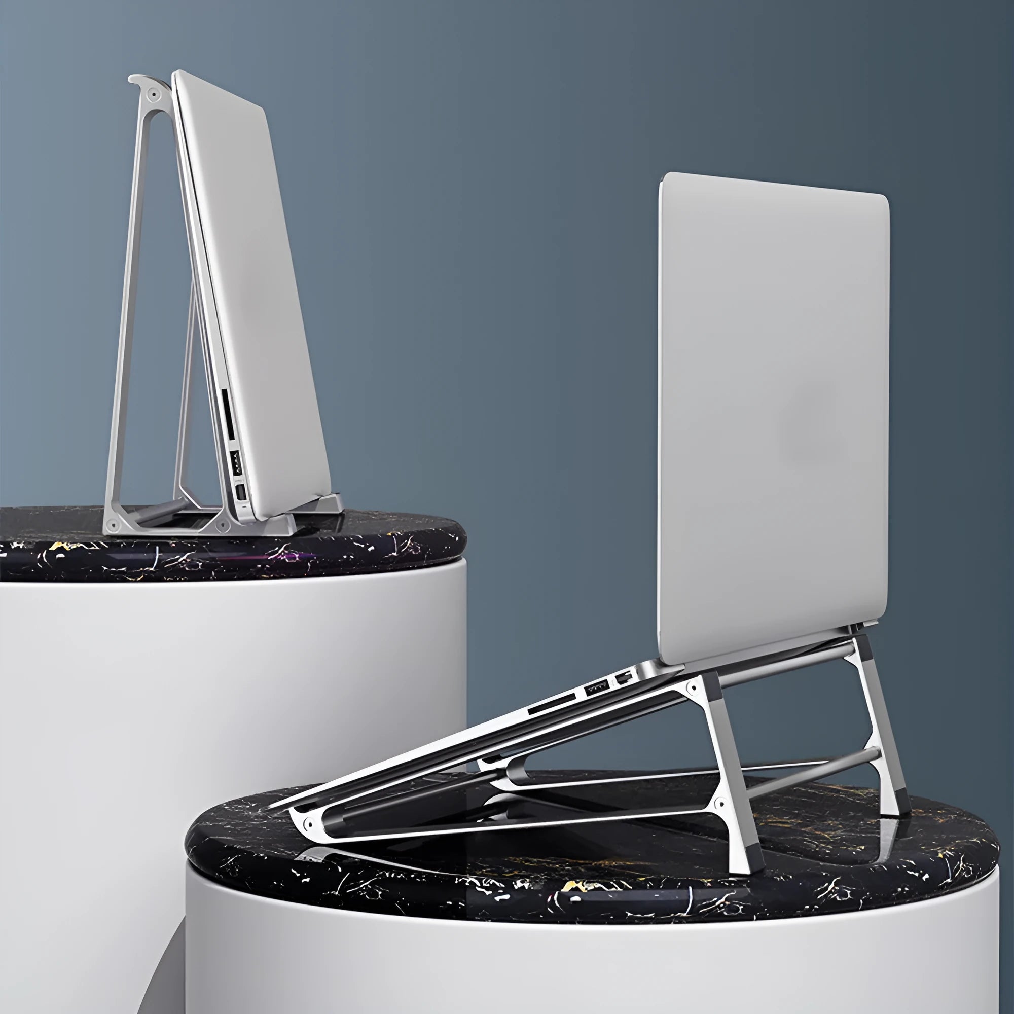 Silver aluminium laptop stand with tablet storage slot underneath, holding a MacBook and an iPad on a desk