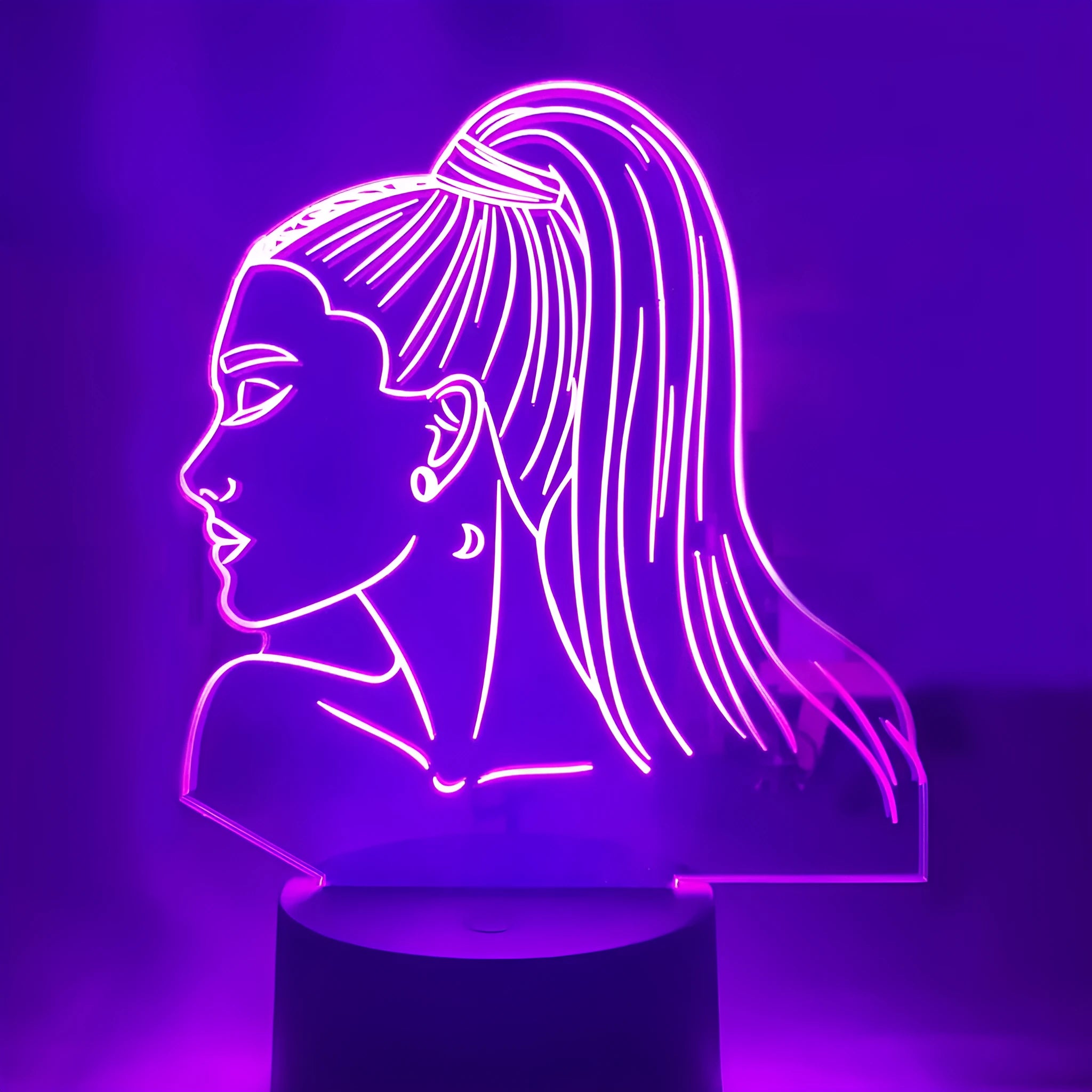 Black based LED desk lamp with colourful acrylic shade and a small remote control on a wooden desk.